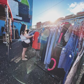 Shopper browsing clothing at a 2023 vintage market